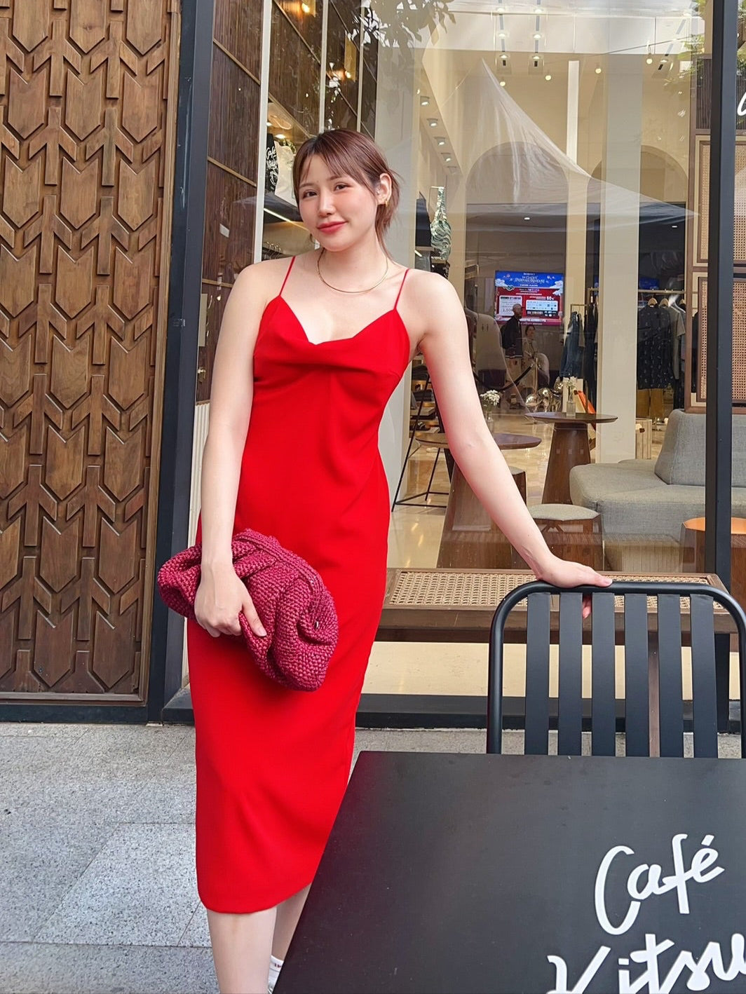 Woman in a red dress standing outside a cafe named 'Cafe Kitaro'.